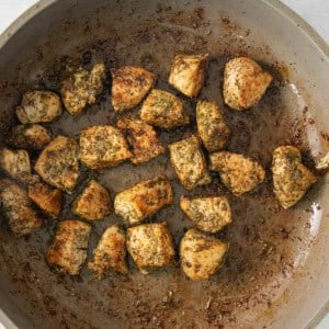 a pan filled with meatballs sitting on top of a stove.