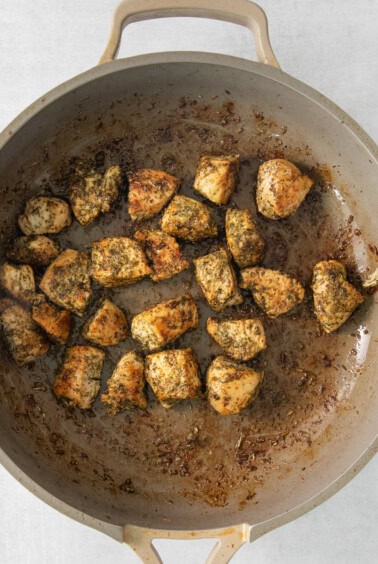 a pan filled with meatballs sitting on top of a stove.