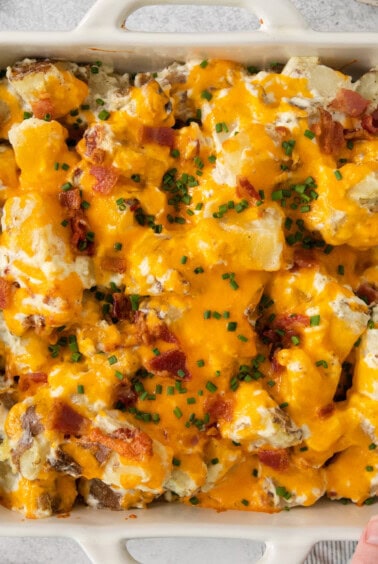 cheesy potato casserole in a white baking dish.