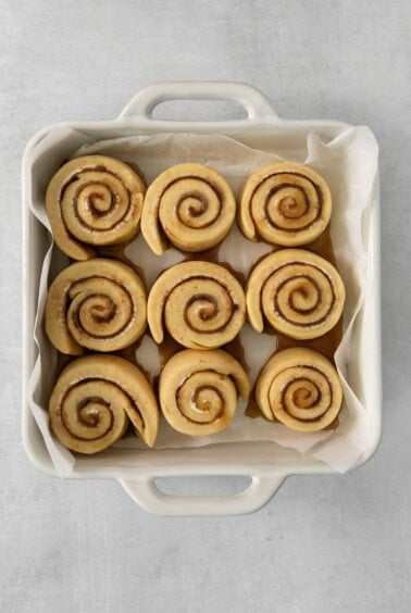 a white container filled with cinnamon buns on top of a table.