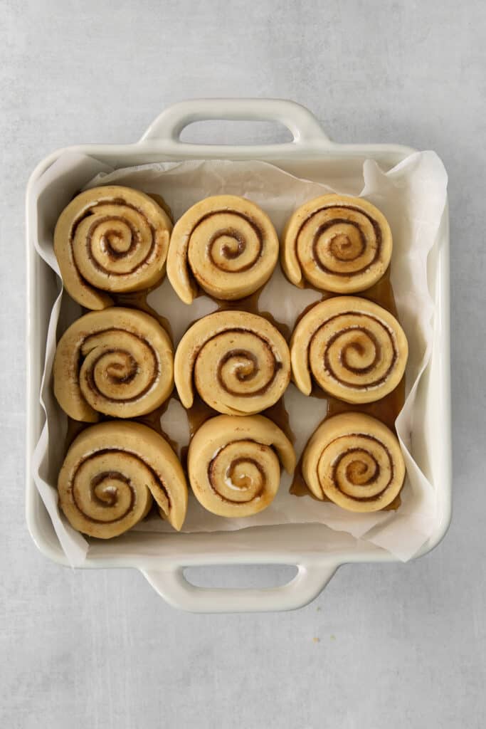 a white container filled with cinnamon buns on top of a table.