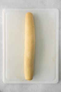 a long piece of bread sitting on top of a cutting board.