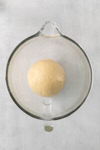 a ball of dough in a glass bowl.