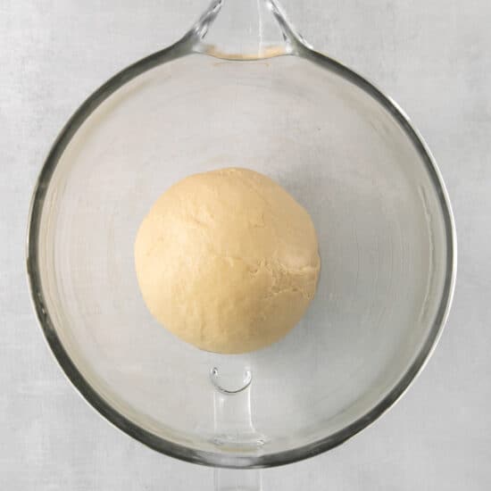 a ball of dough in a glass bowl.