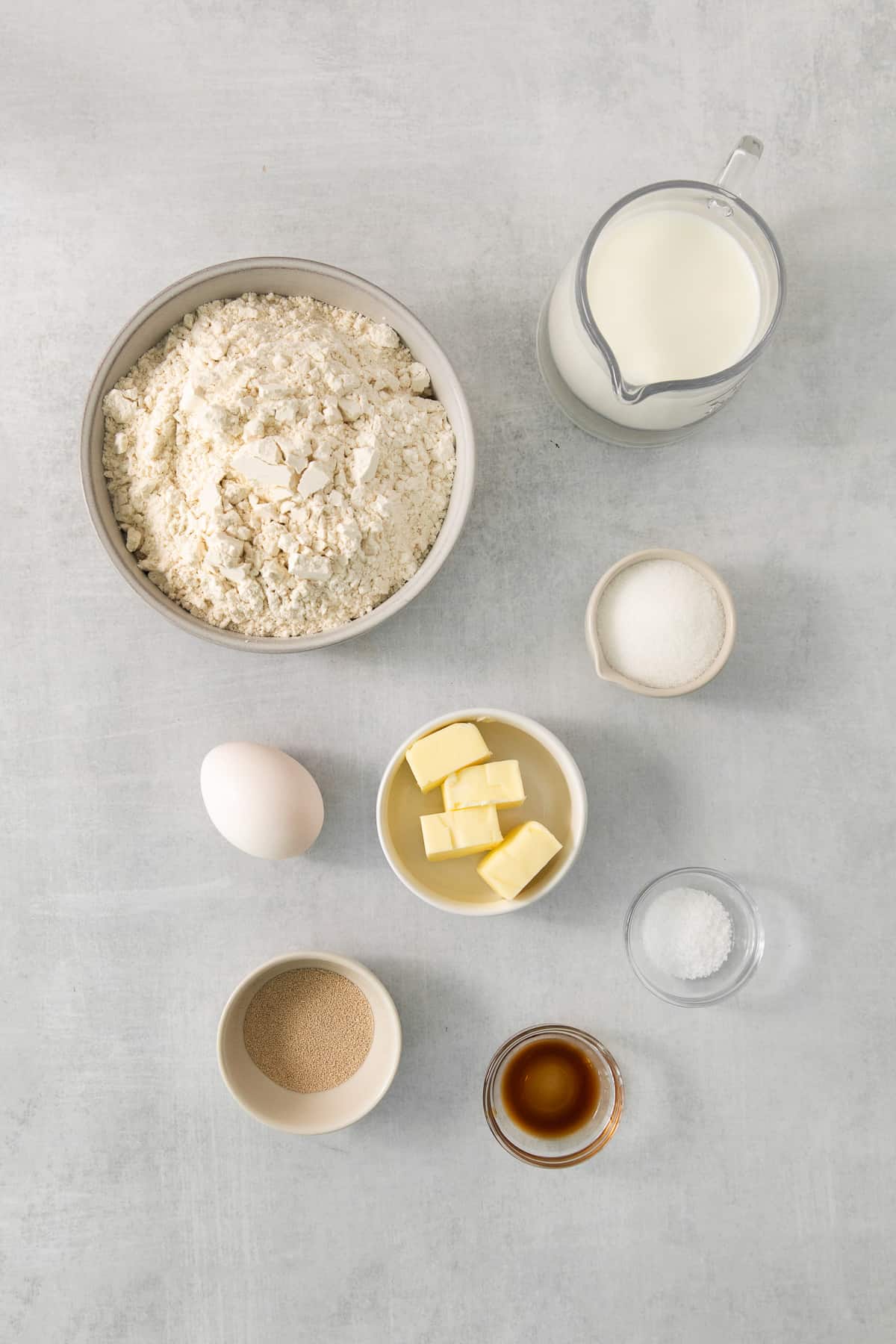 a table topped with bowls of food next to a cup of milk.