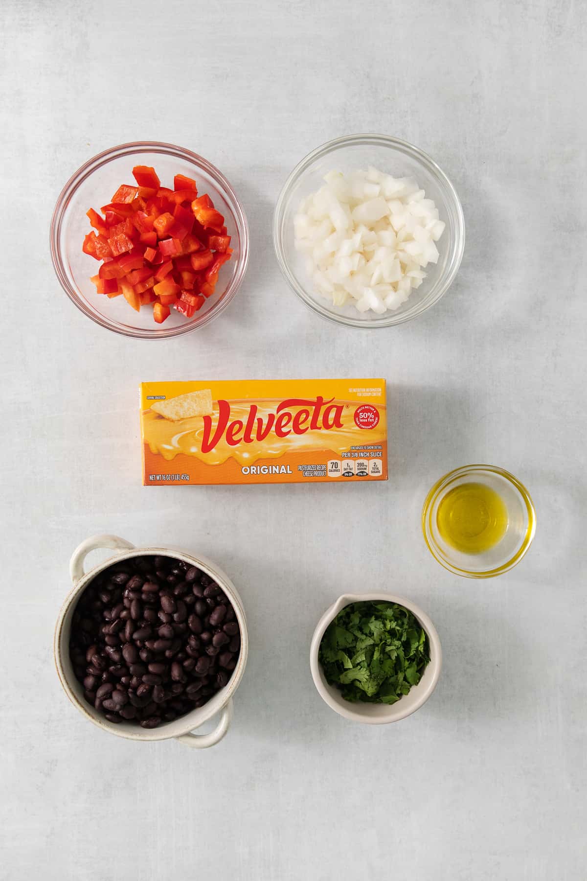 a table with bowls of food and a carton of velveeta.