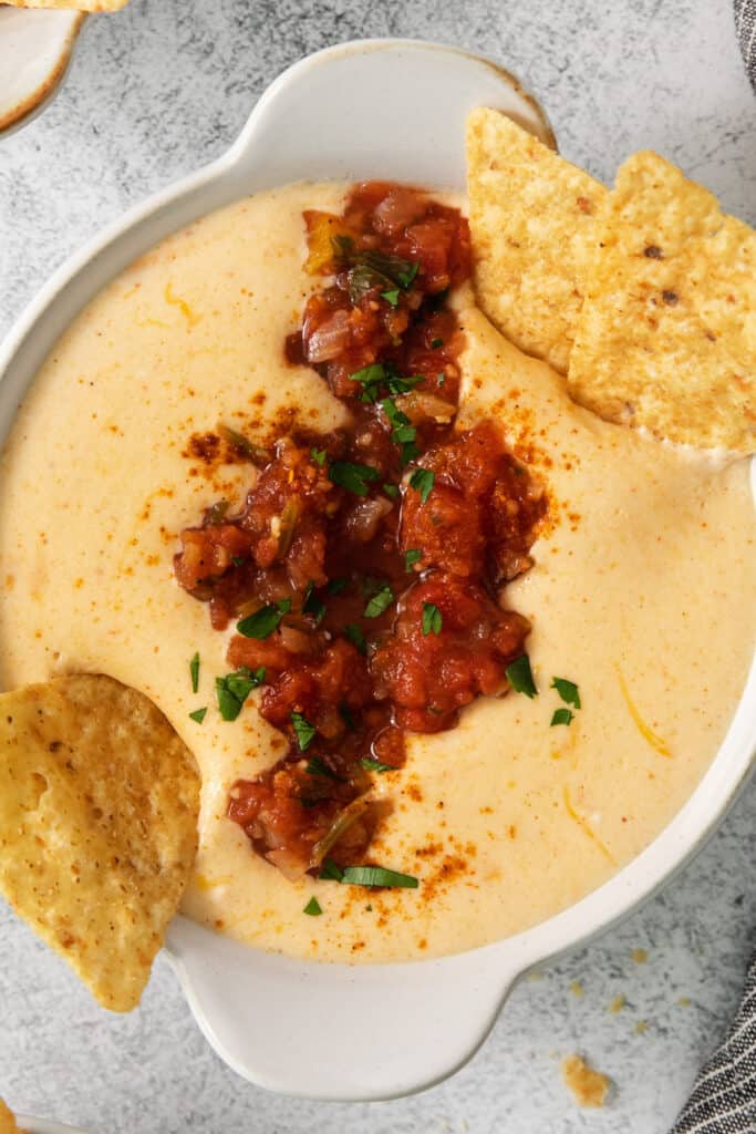 a bowl of cheesy dip with tortilla chips.