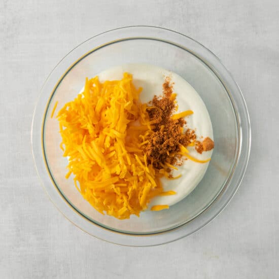 a bowl of yogurt with shredded carrots and granola.