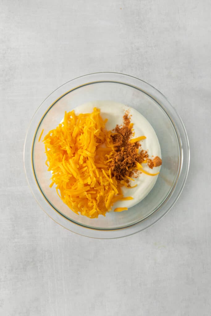 a bowl of yogurt with shredded carrots and granola.