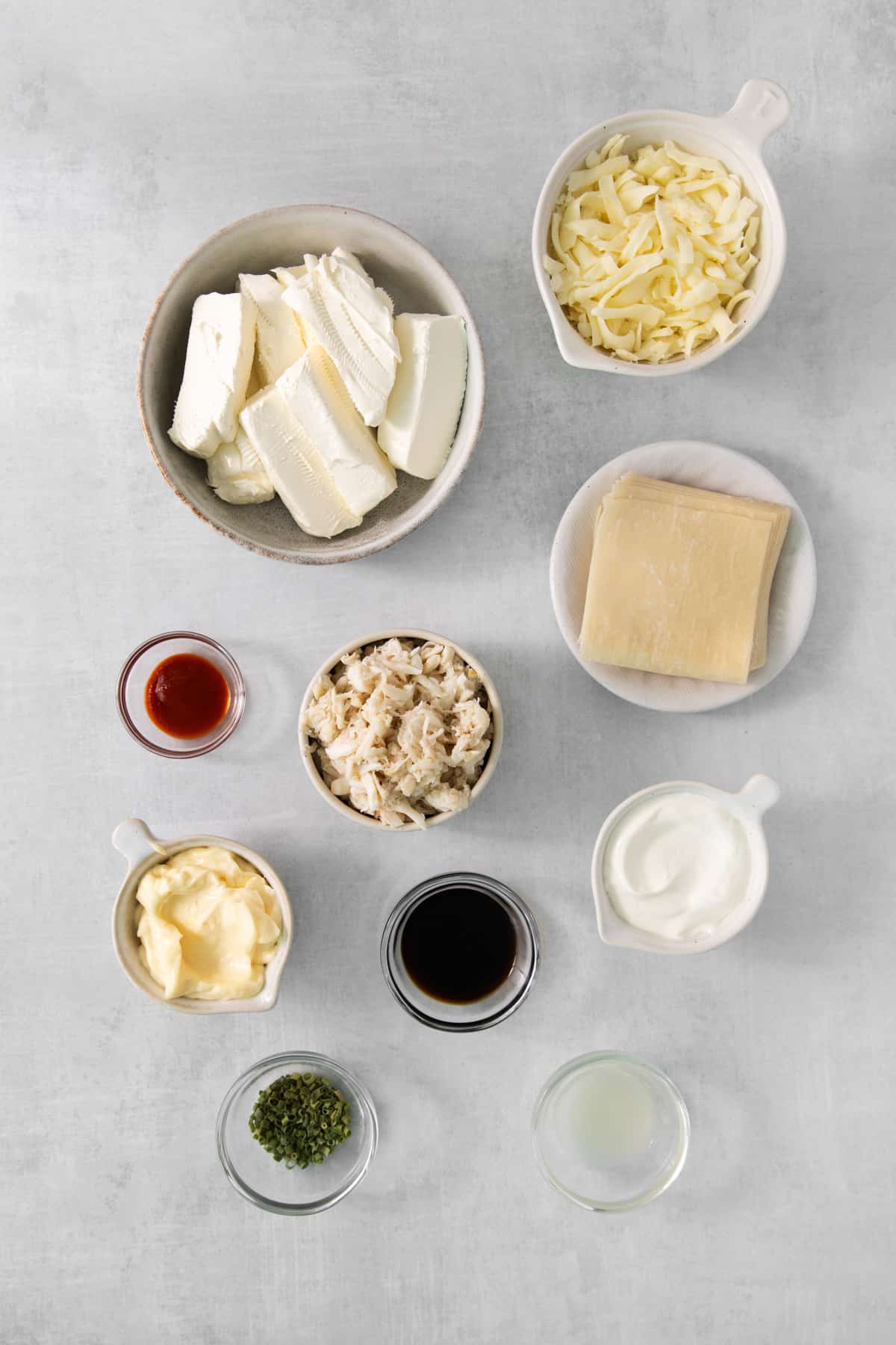 the ingredients for a cheesy tofu dish on a grey background.