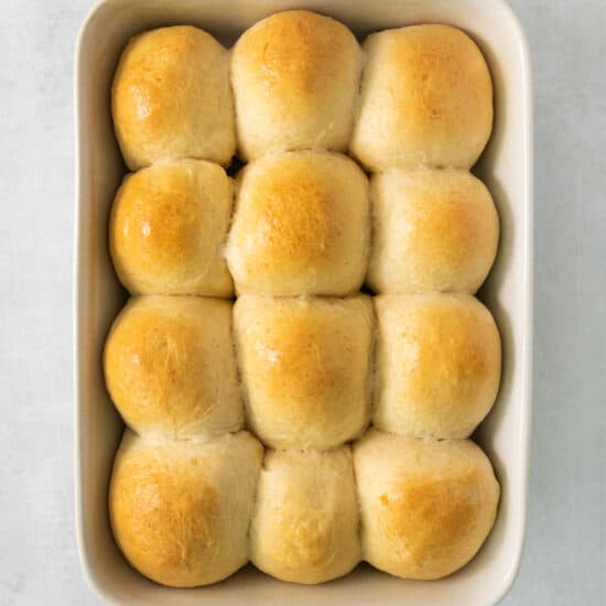 bread rolls in a baking dish on a white background.