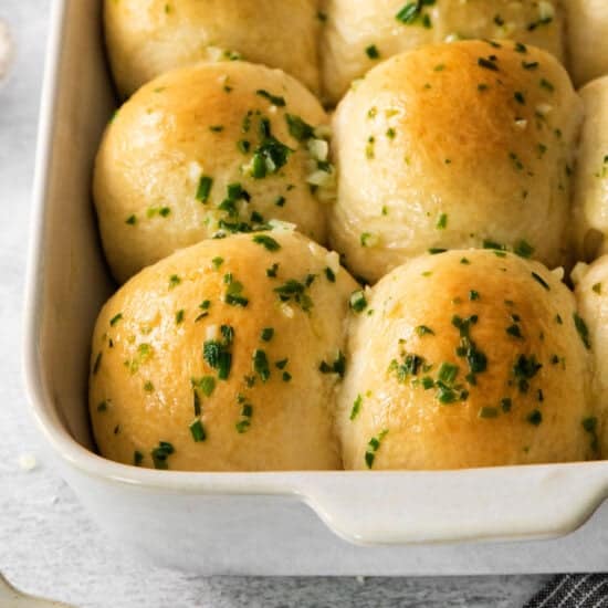 cheesy garlic rolls in a white baking dish.