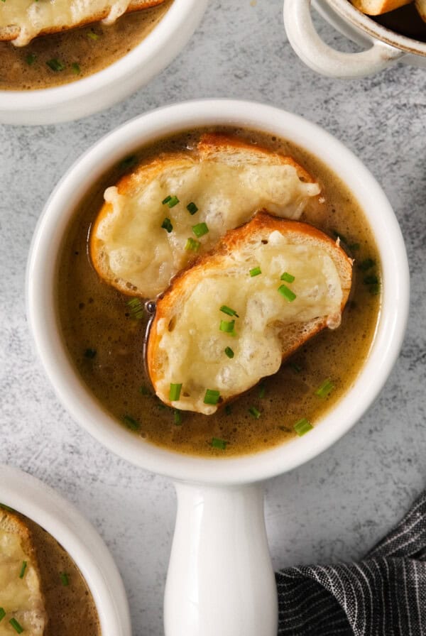 a bowl of soup with croutons and parmesan cheese.