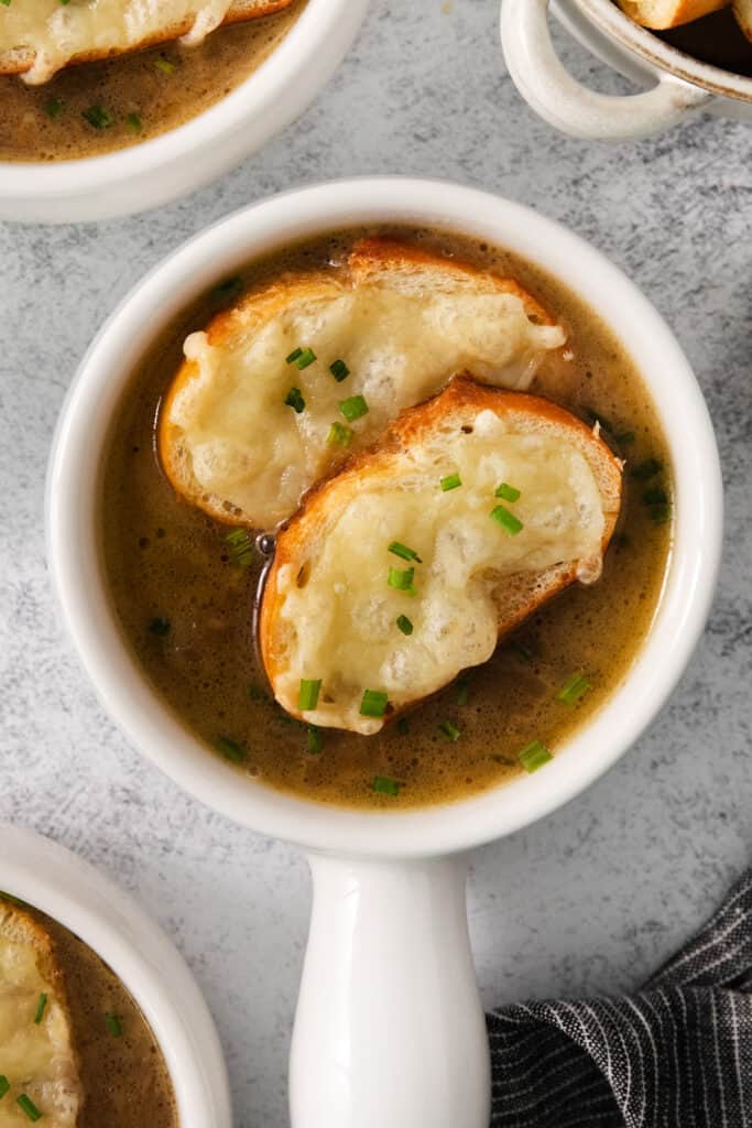 a bowl of soup with croutons and parmesan cheese.