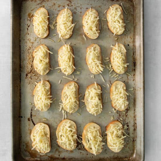cheesy crostini on a baking sheet.