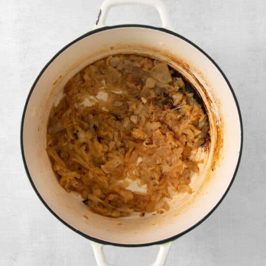 onion soup in a white pot on a white background.