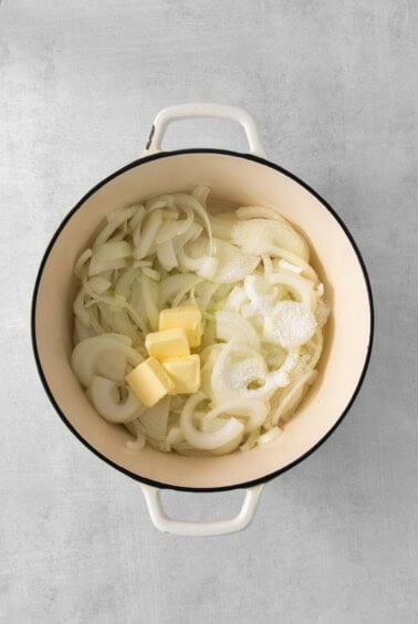 onion and butter in a pot on a grey background.