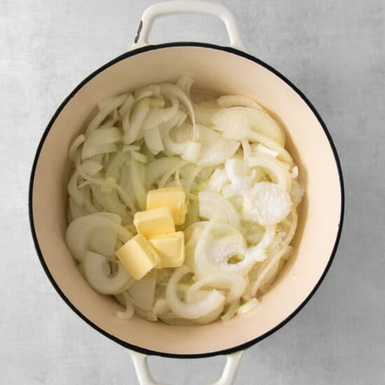 onion and butter in a pot on a grey background.