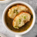 french onion soup in a white bowl with croutons.