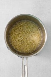 A frying pan filled with oil on a white surface.