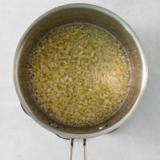 A frying pan filled with oil on a white surface.