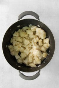 Mashed potatoes in a pot on a white background.