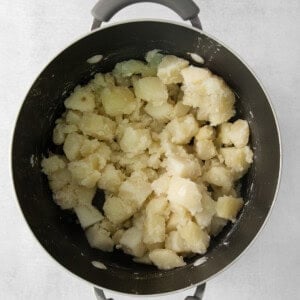 Mashed potatoes in a pot on a white background.