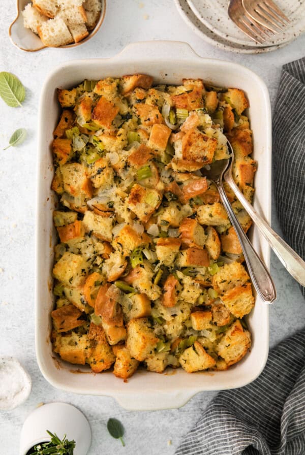 Bread stuffing with sage and chives in a white dish.