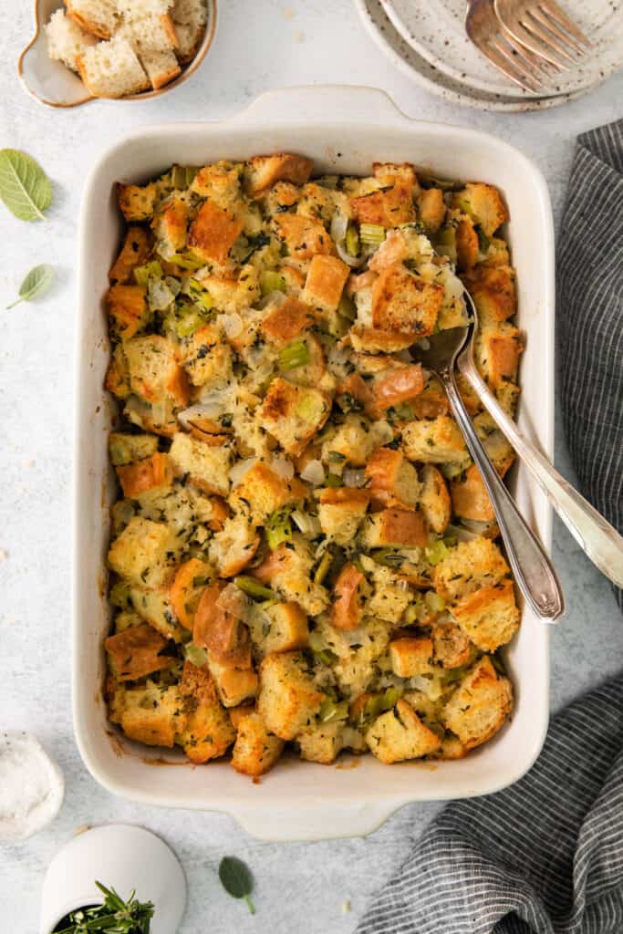 Bread stuffing with sage and chives in a white dish.