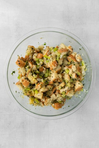A clear bowl of stuffing on a table.