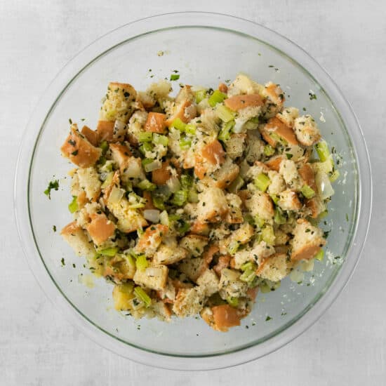 A clear bowl of stuffing on a table.