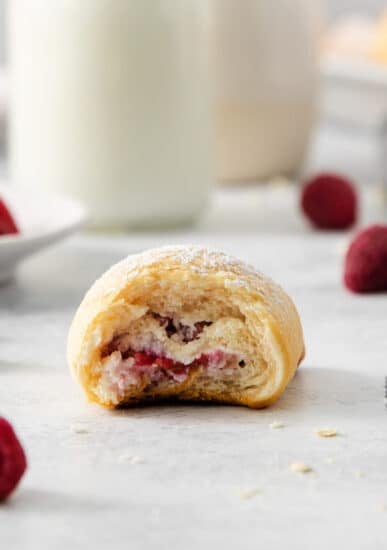 a raspberry pastry with a bite taken out of it.