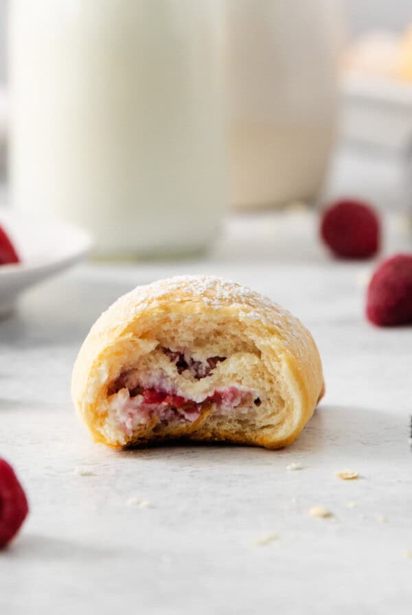 a raspberry pastry with a bite taken out of it.