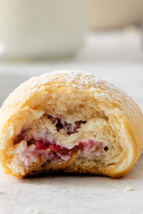 a raspberry pastry with a bite taken out of it.