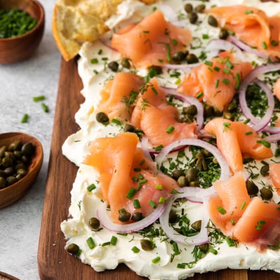 a smoked salmon and cream cheese tart on a wooden cutting board.