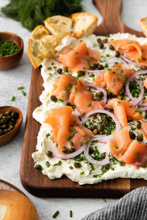 a smoked salmon and cream cheese tart on a wooden cutting board.