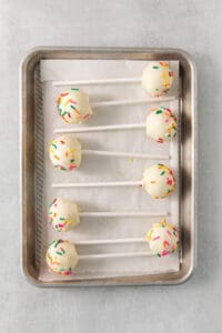 cake pops with sprinkles on a tray.