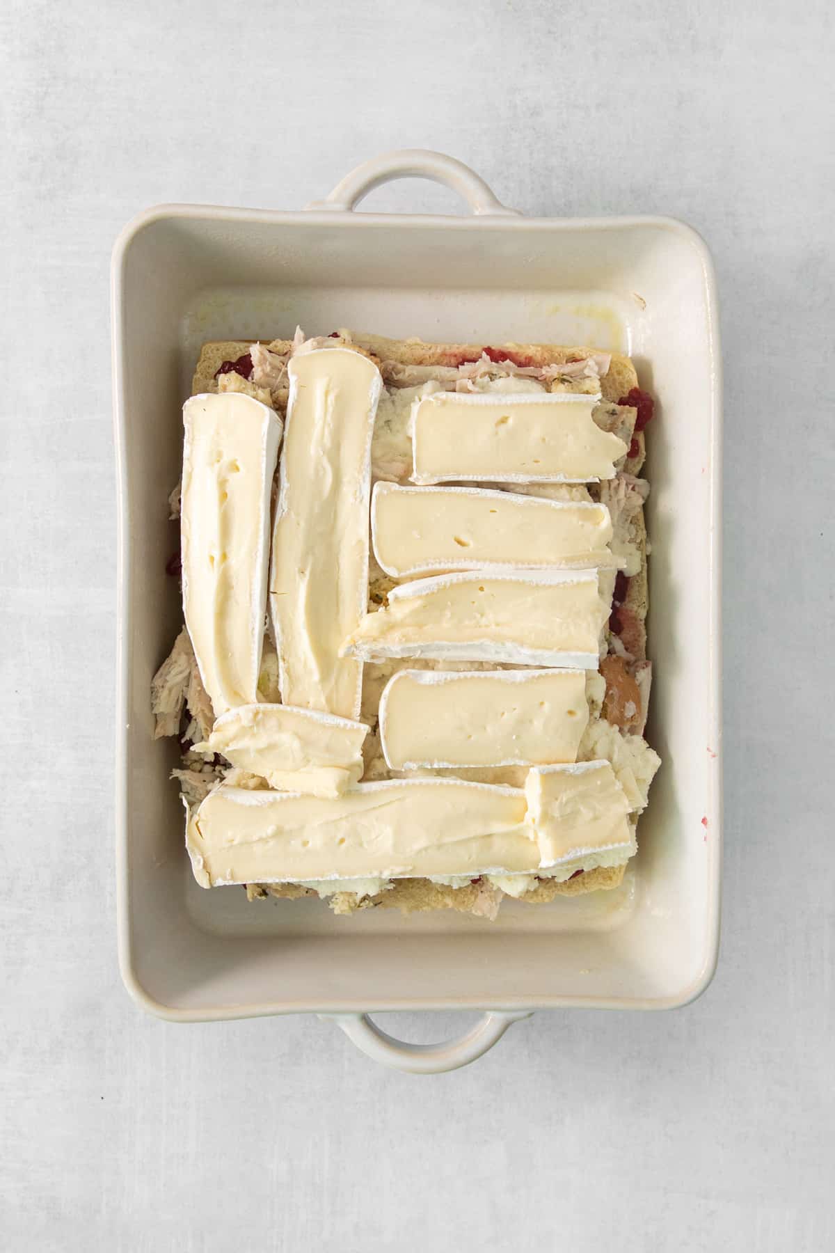 A square baking dish with a piece of cheese on it.