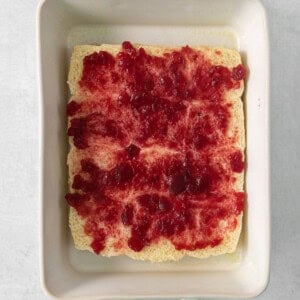 A square baking dish with a piece of cake in it.