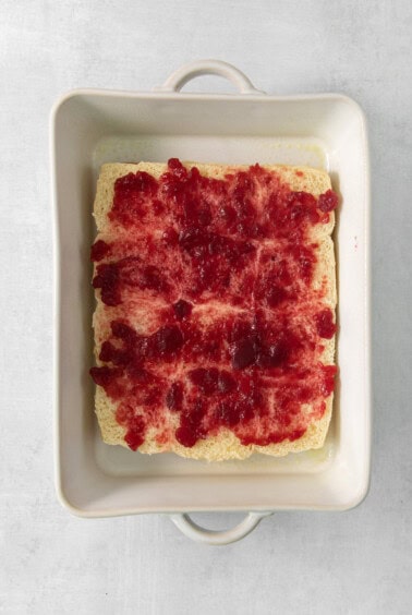 A square baking dish with a piece of cake in it.