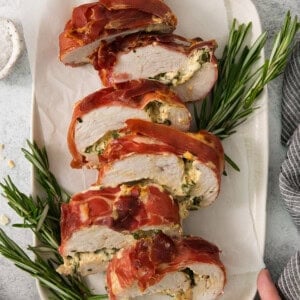 A plate of bacon wrapped chicken with sage and rosemary.