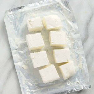 A plastic bag containing tofu on a marble countertop.