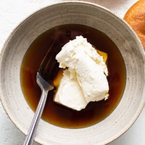 A bowl of bagels with cream and a fork.