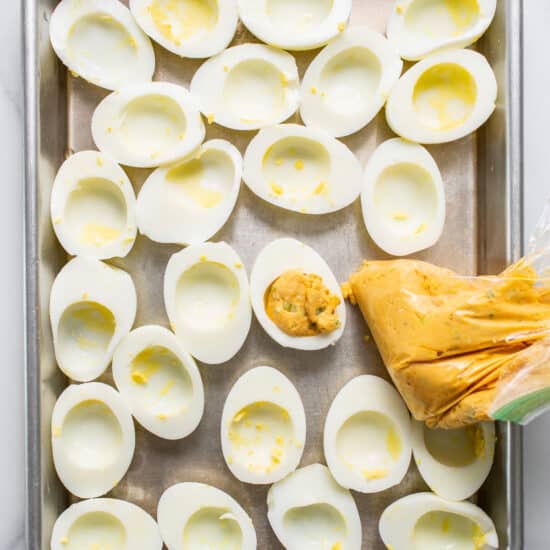 Deviled eggs on a baking sheet.