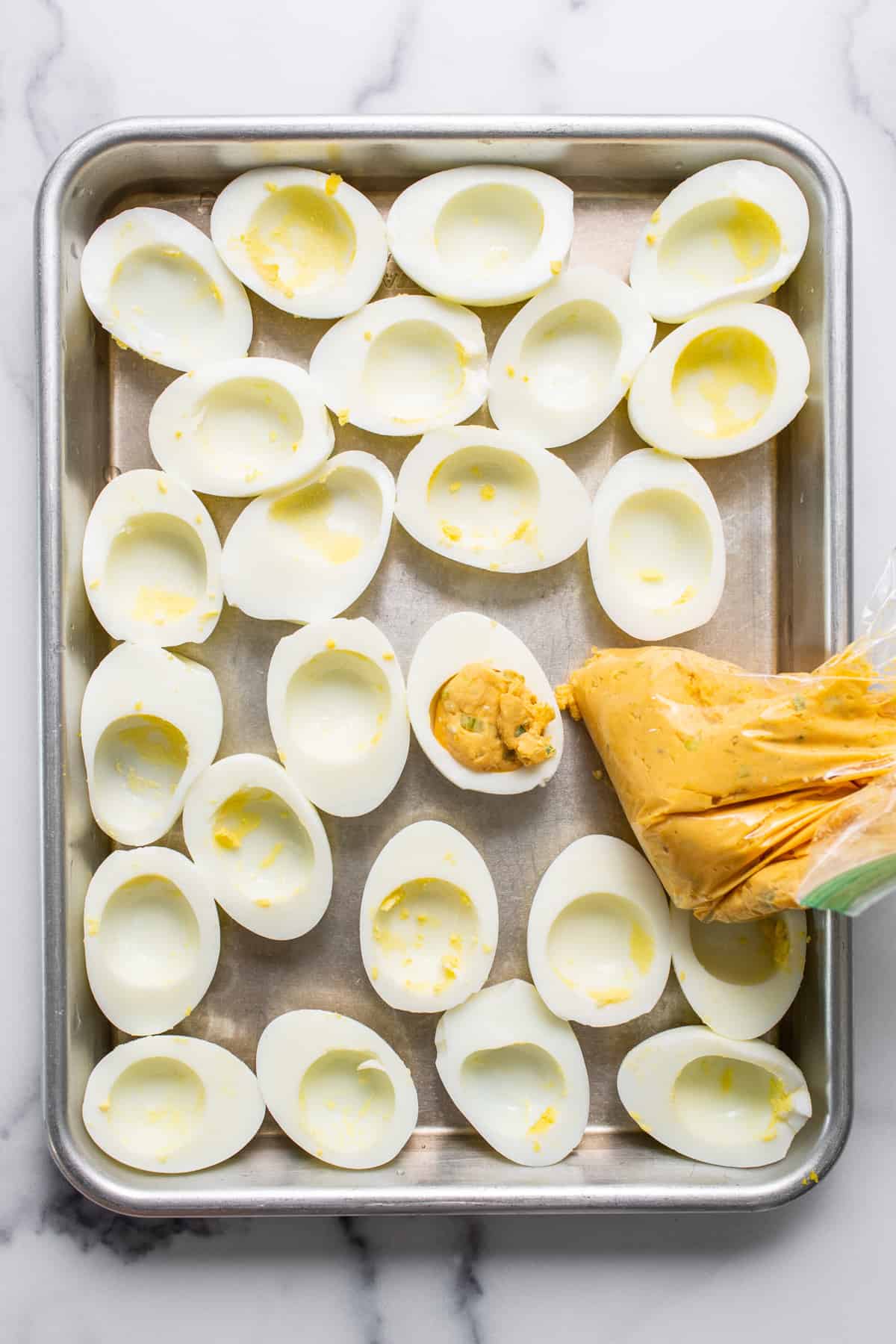 Deviled eggs on a baking sheet.