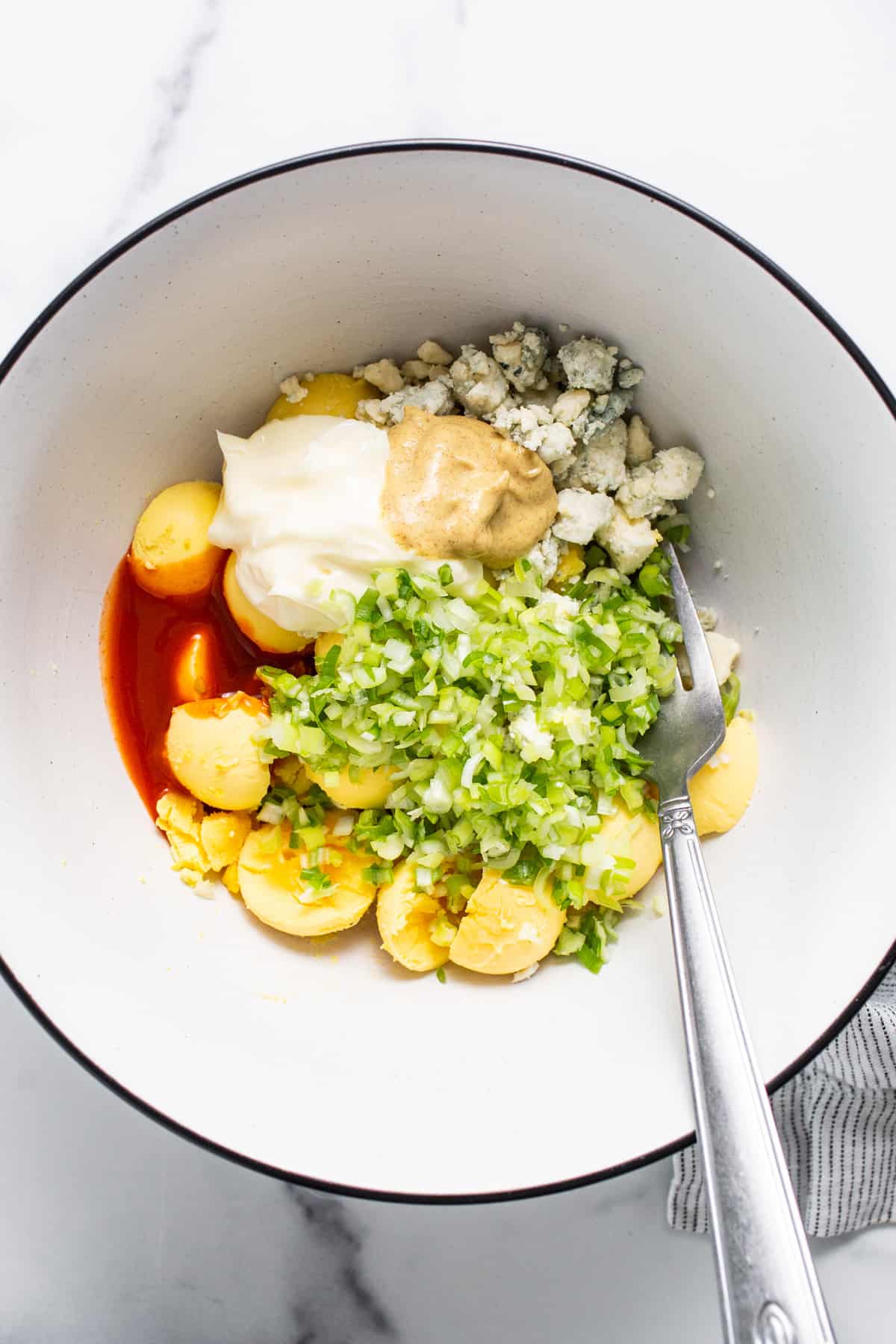 A bowl filled with vegetables and a fork.