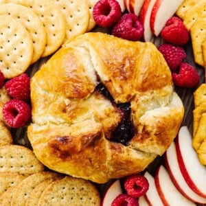 A platter of fruit, crackers and crackers.