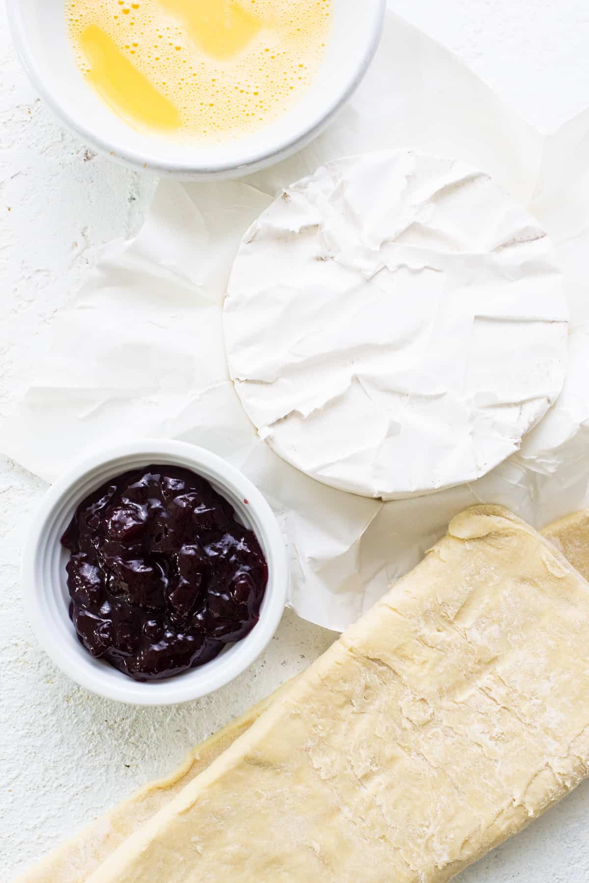 A plate with cheese, jam, and bread.