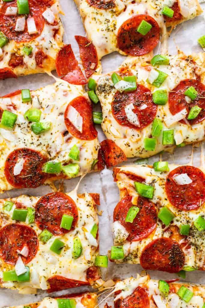 Pepperoni pizza slices on a baking sheet.