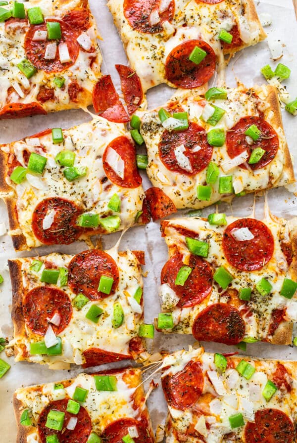 Pepperoni pizza slices on a baking sheet.